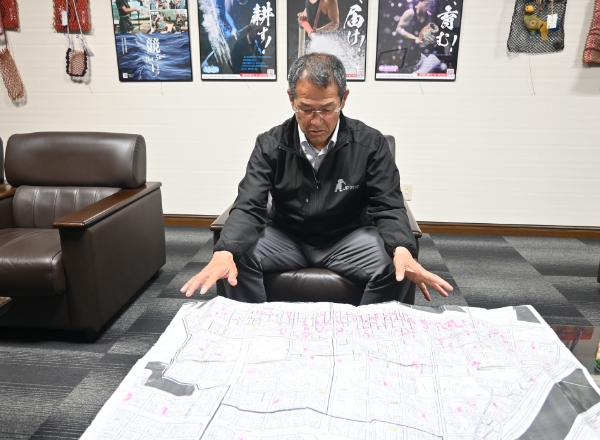 漁家台帳をもとに、組合員の居住地が一目で分かる地図を作成している戎本さん